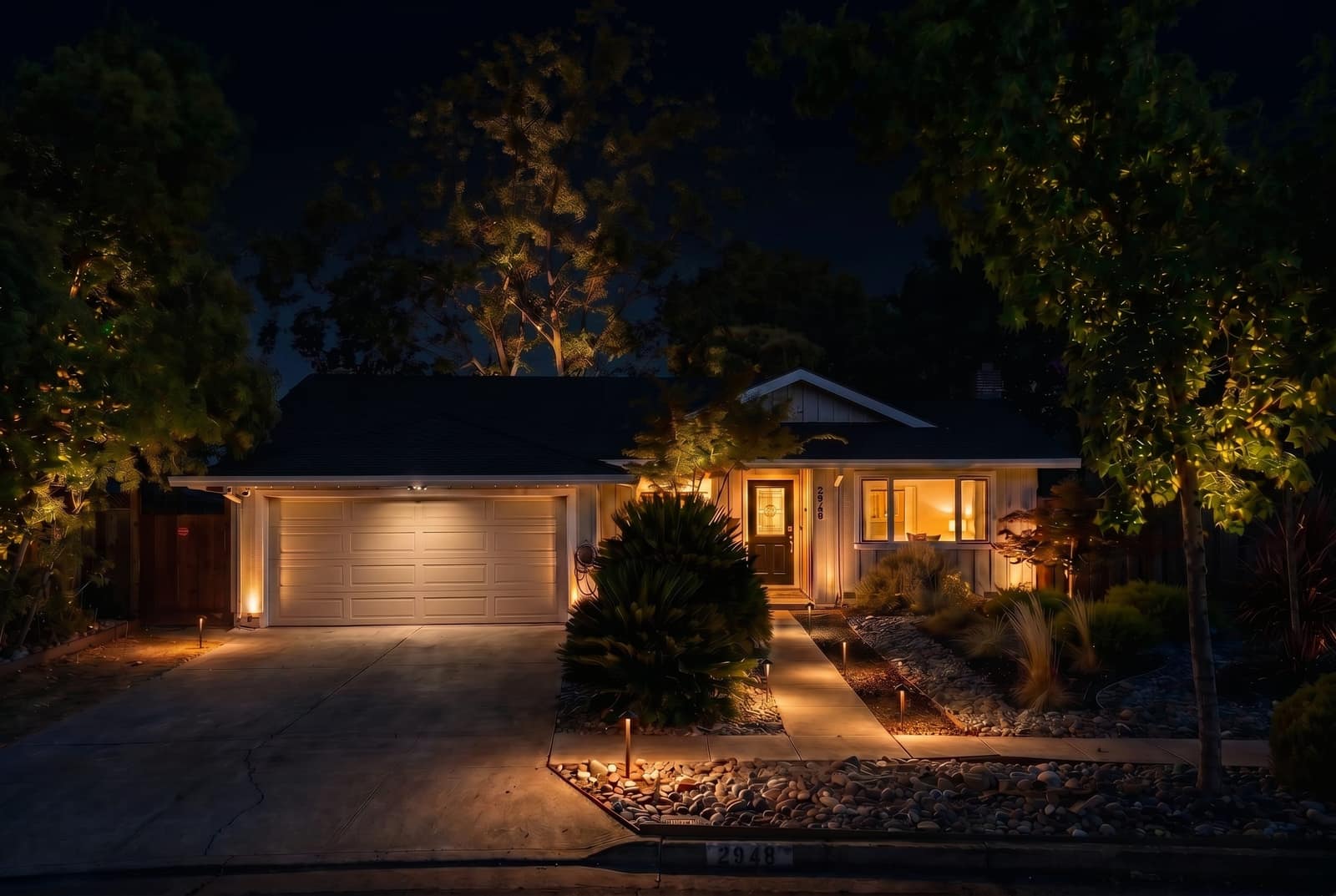 The house at night, with the lighting design built and lit.