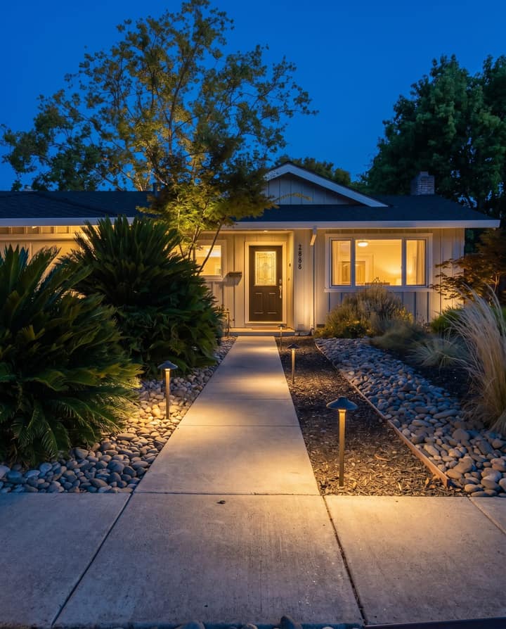 The front walk at night, low pools of light leading to the door.